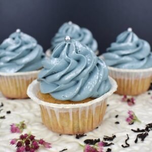 Close-up of blue frosted cupcakes with floral decoration. Perfect for parties and celebrations.