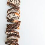 Delicious sliced chocolate swirl bread on a clean white surface, perfect for bakery or café marketing.