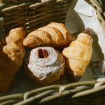 Delicious assortment of croissants and pastries in a wicker basket, perfect for breakfast or a sweet treat.